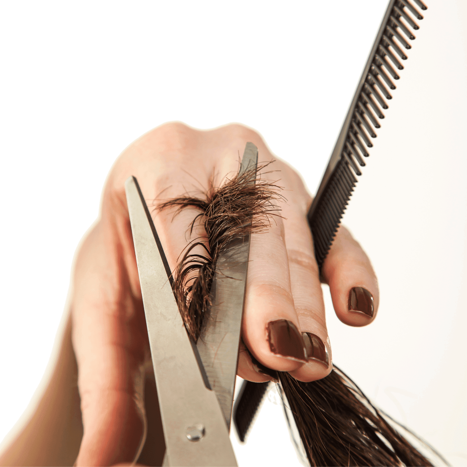 Cutting hair with scissors and comb in hand.